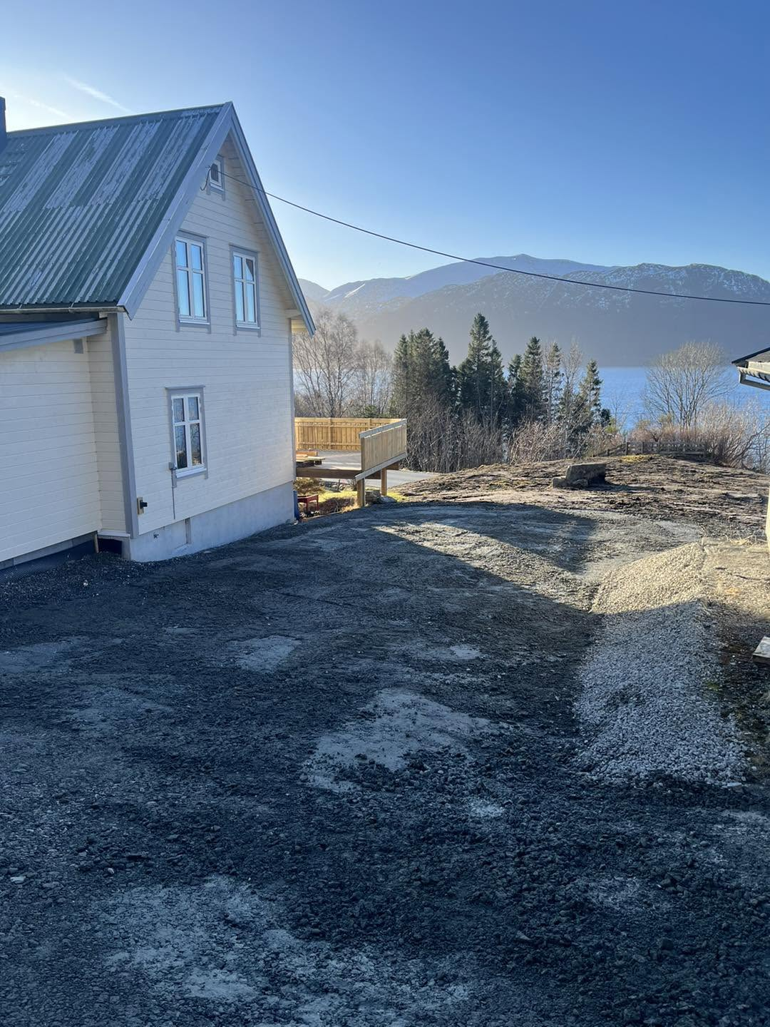 Nyplanert grusflate ved huset med utsikt over fjorden og fjella